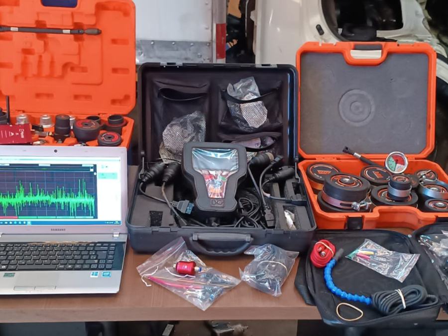 Scanner, notebook e maletas de diagnóstico sobre a bancada