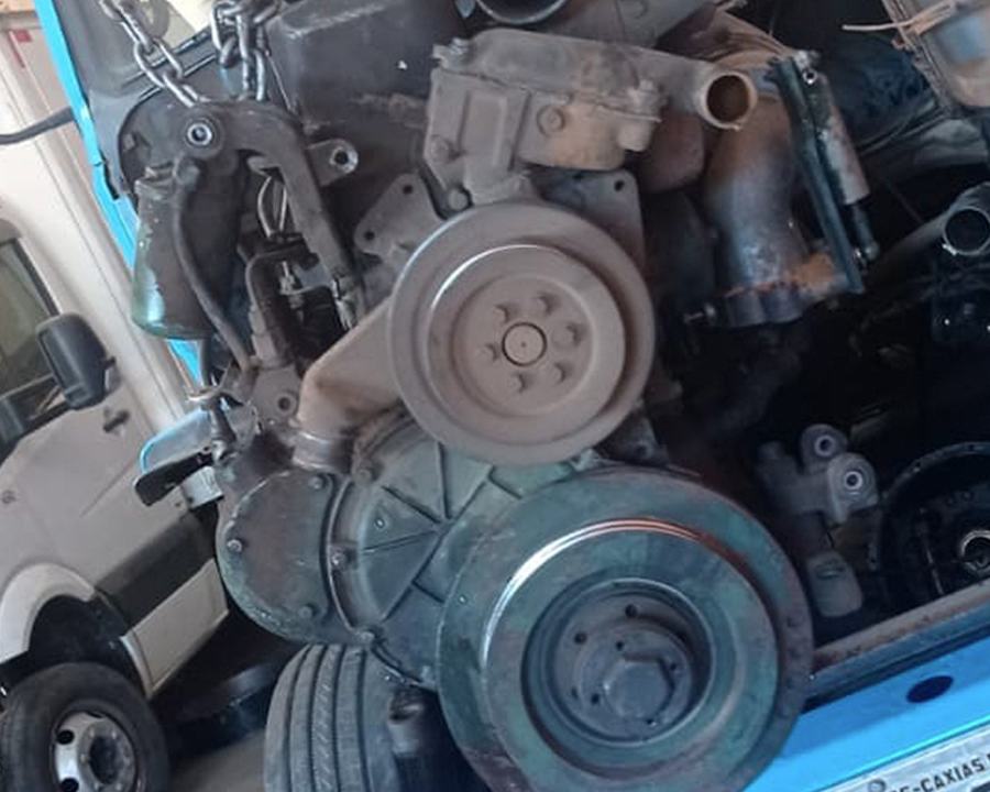 Motor diesel suspenso na talha durante reparo na oficina DMK